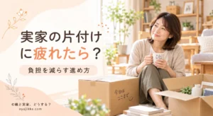 段ボールに囲まれて座り、マグカップを手にひと休みする40代女性